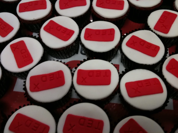 a bunch of cupcakes that have been decorated with red and white icing