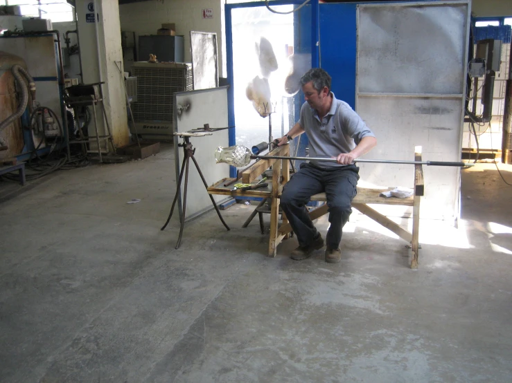 man working with tools in a workshop on the side