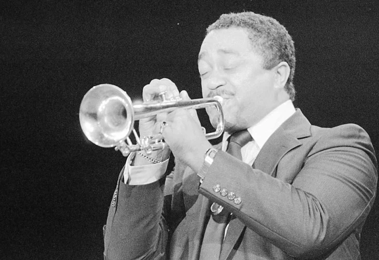 a black and white image of a man playing the trumpet