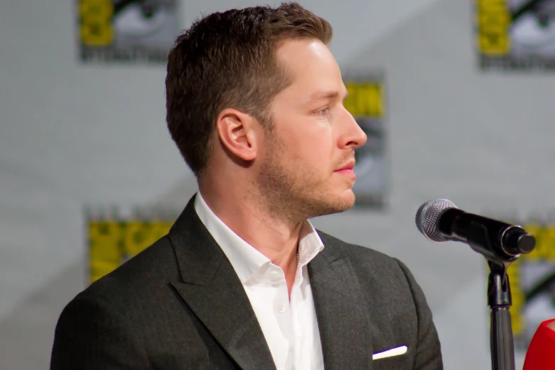 a man is standing at a podium in front of a microphone