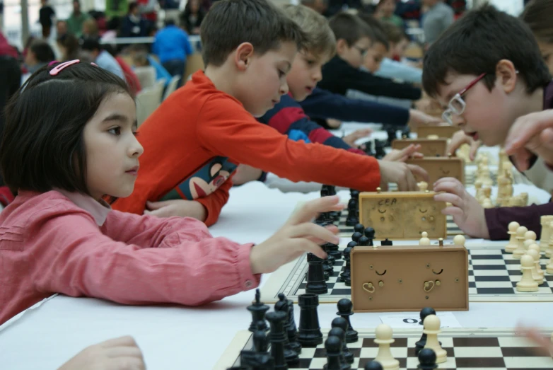 a group of children playing chess at the park