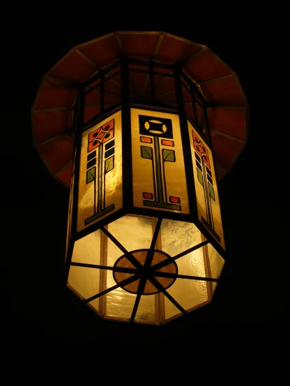 a stained glass and metal fixture is lit