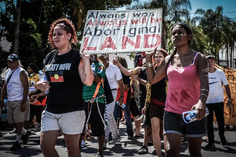 a large group of people holding signs in the streets