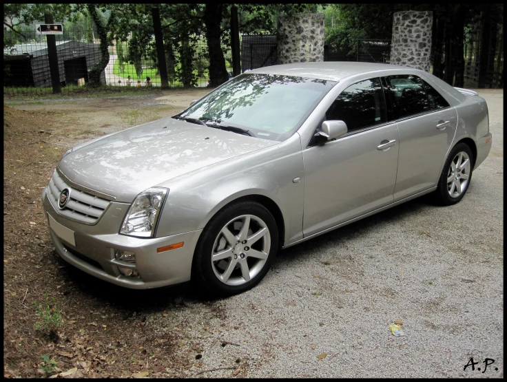 a gray car parked on top of a gravel road