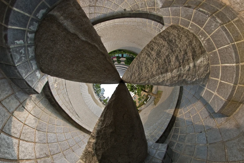 the view from inside a stone tower looking up at an area with rock slabs