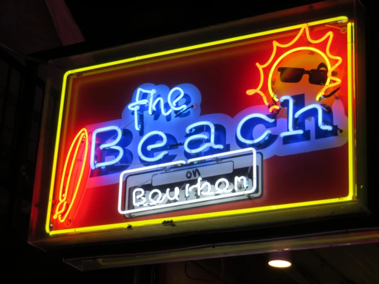 the sign for the beach is lit up