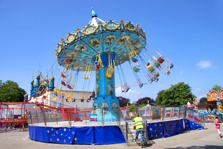 a blue carousel at the carnival on a clear day