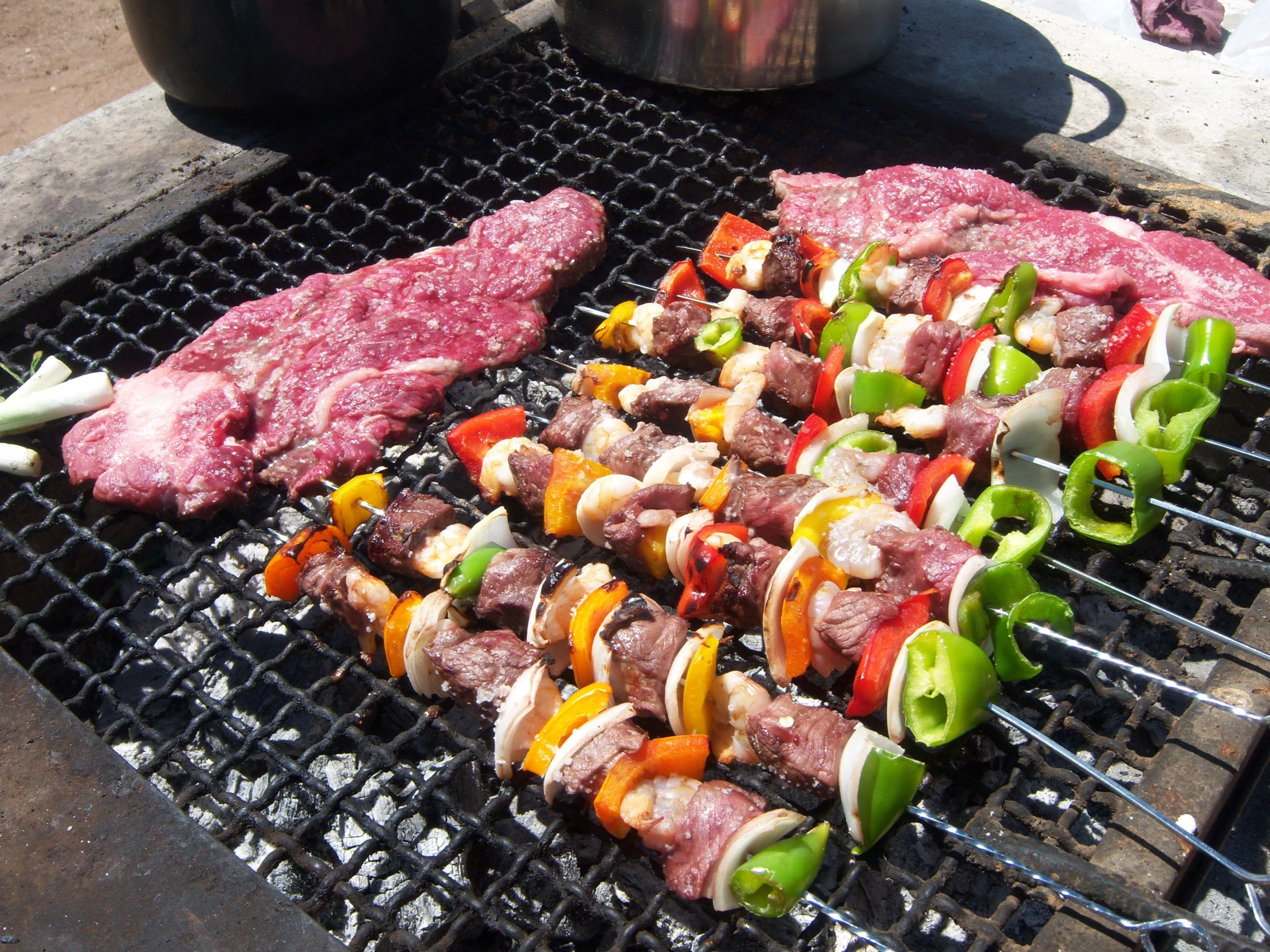 a bunch of steak skewers being cooked on a grill