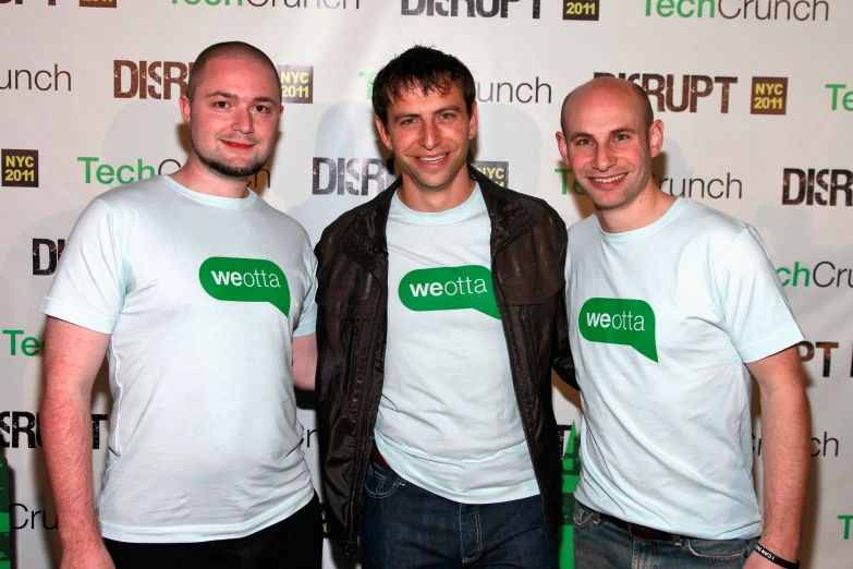 three men standing next to each other in white t - shirts