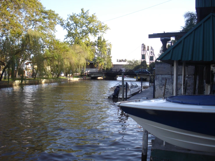 a boat moving down the river, and another boats parked along it