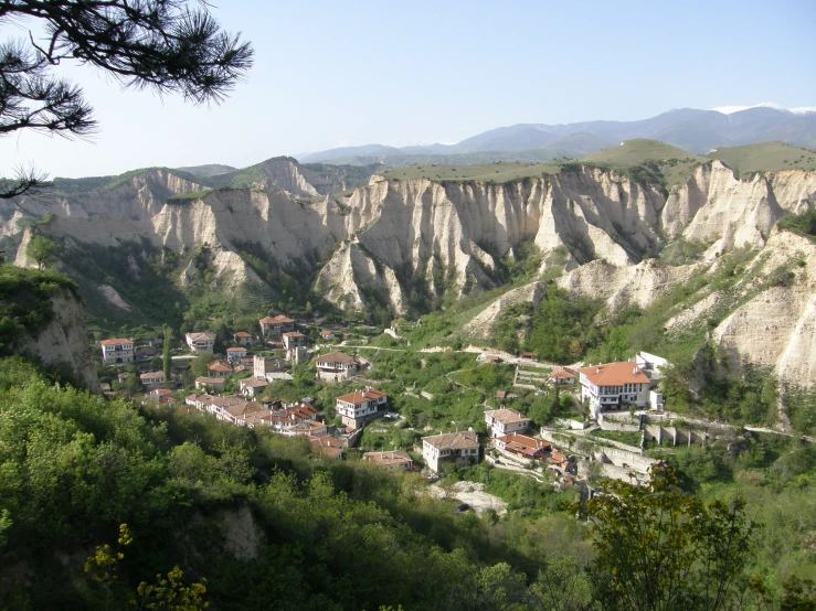 the village is nestled between mountains and green valleys