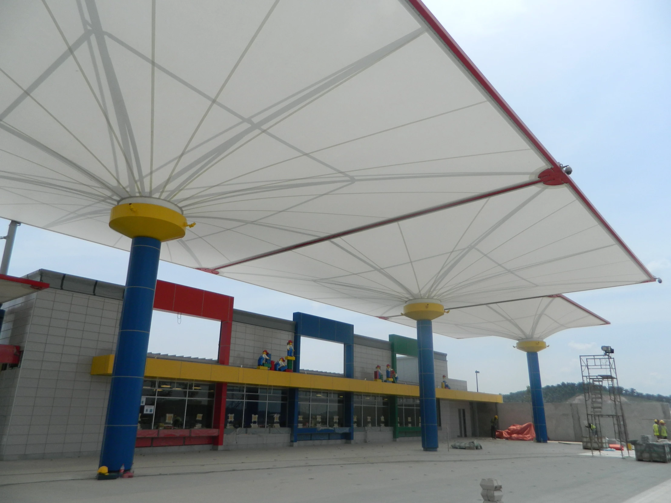 white umbrella covers on several poles over a building