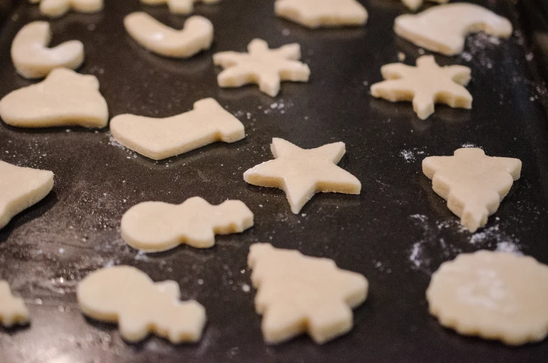 short or long shaped biscuits are on a cookie sheet