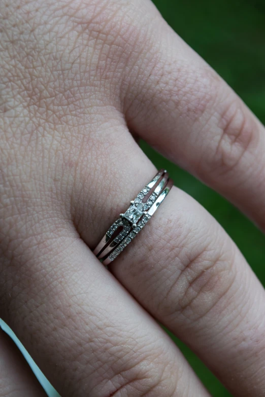 a person with two different engagement rings on their fingers