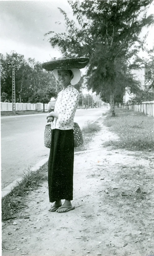 an old po shows a woman carrying objects on her head