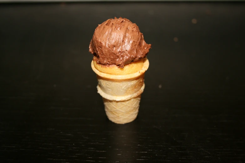 three scoops of chocolate ice cream in a cone