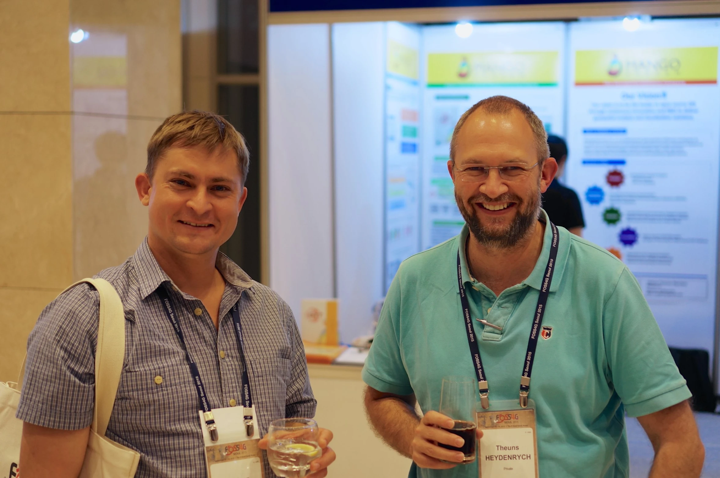 a couple of men holding drinks and posing for a po