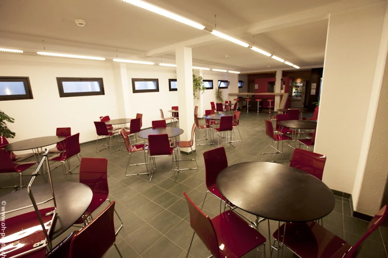 a room filled with red tables and chairs