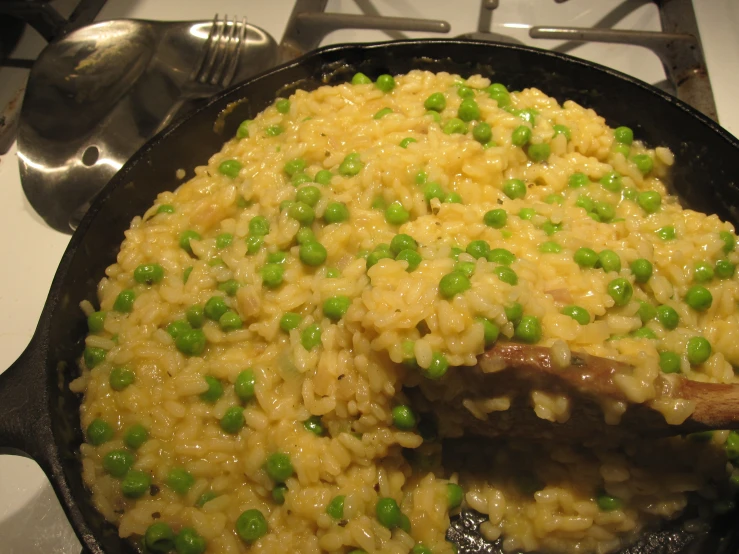 a set full of rice, peas, and meat on the stove