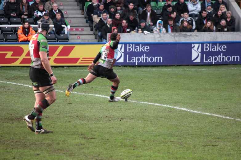 rugby players on a field kicking the ball