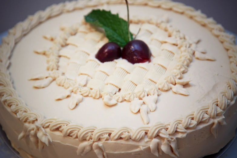 a cake with white icing and two cherries