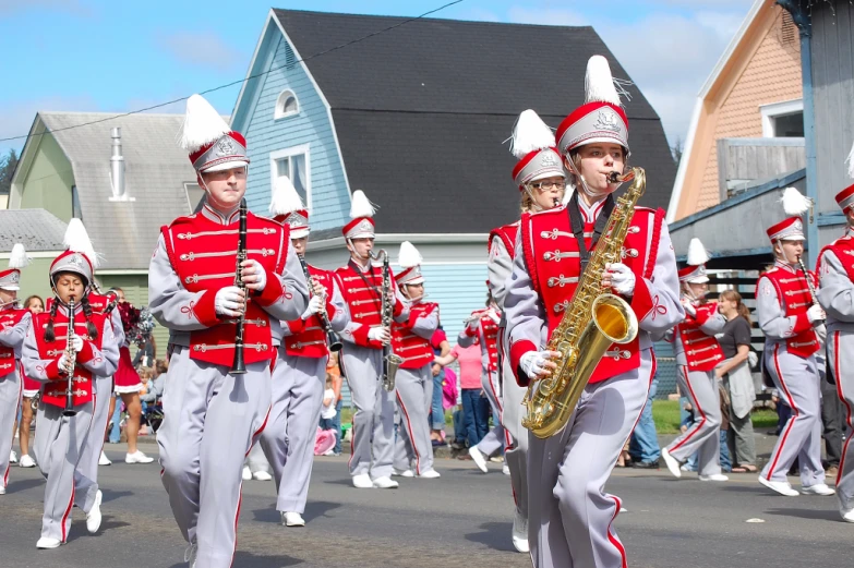 a group of men in red and gray uniforms marching down the street