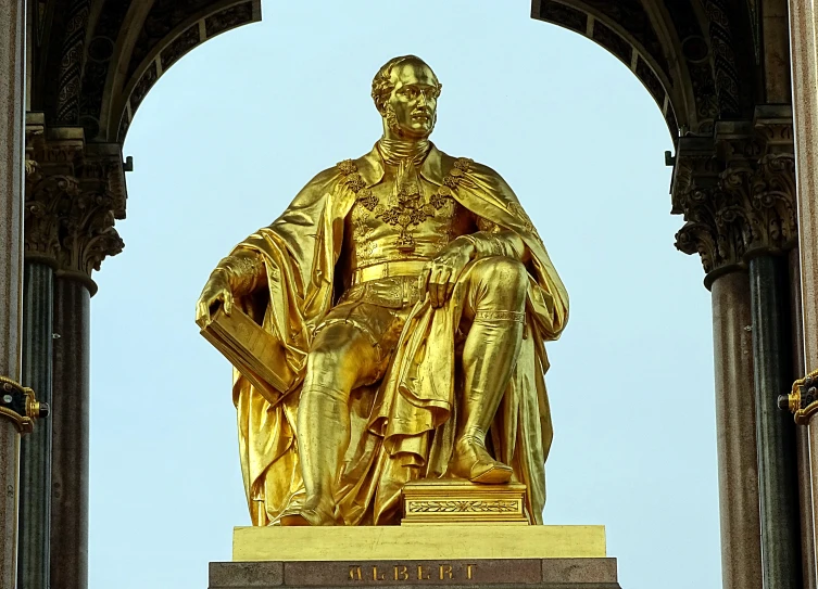 a large golden statue of an man in front of a building