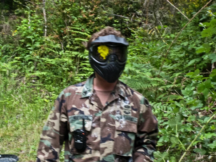 a man wearing a gas mask standing on a dirt road