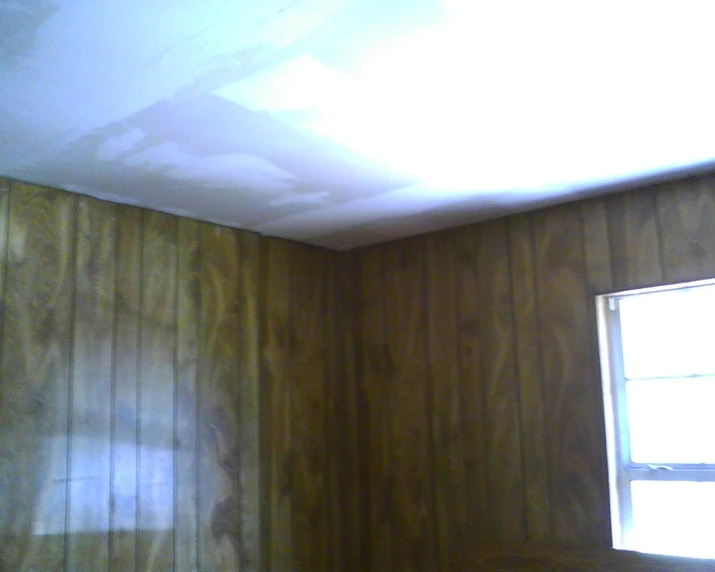 an empty room with a ceiling being painted