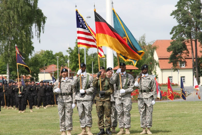 a group of soldiers saluting in front of some flags