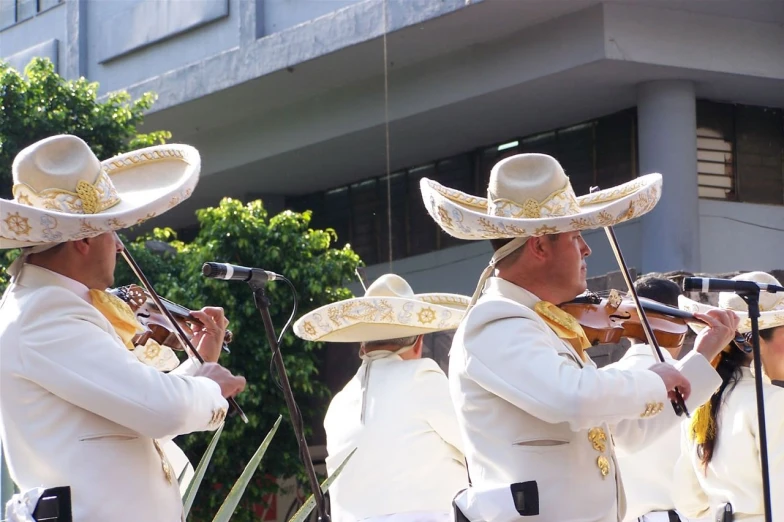 a band wearing sombreros playing instruments in the street