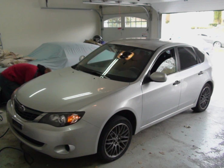 the silver car is parked in the garage