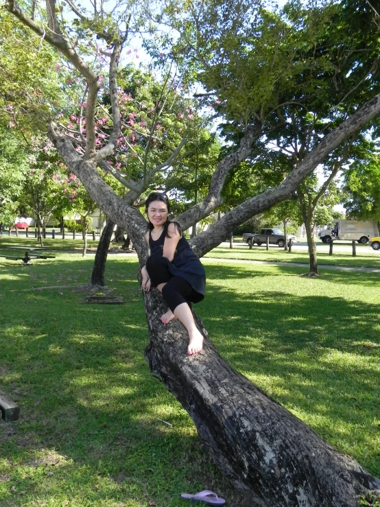 a girl sitting on a log posing for a picture