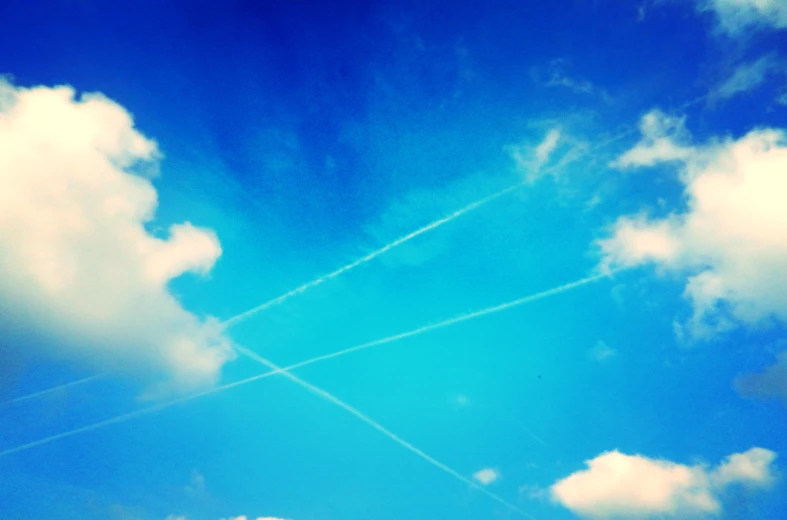 planes are flying high up in the blue sky