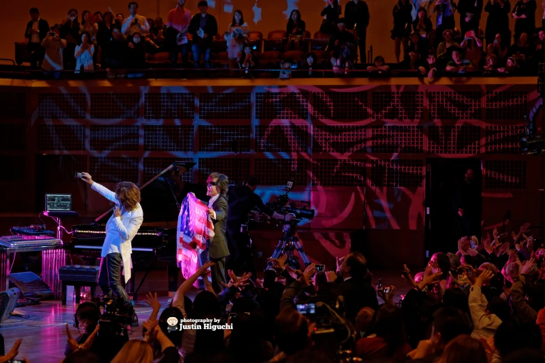 the two performers perform at an audience - ridden concert