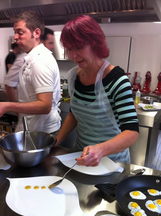 a couple of people in a kitchen making some food