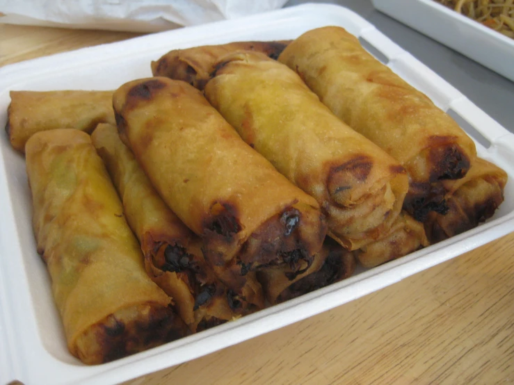 a container filled with rolls covered in cheese