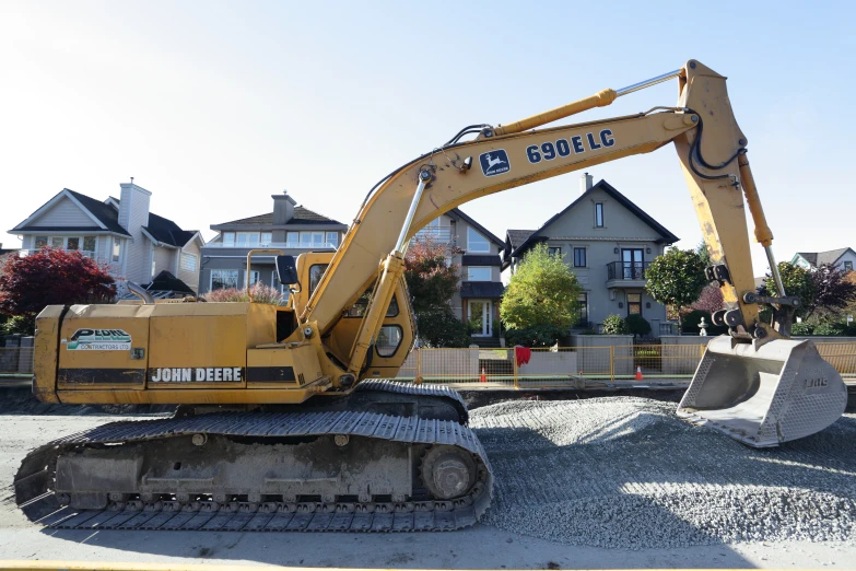 a yellow excavator is on gravel outside