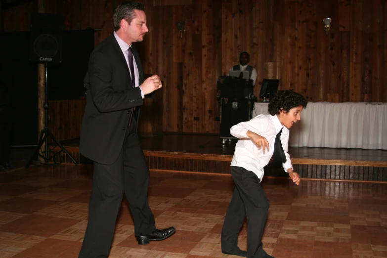 the  in the white shirt is dancing with his dad