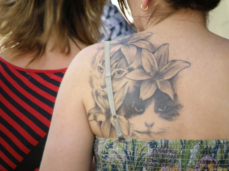 woman's back, wearing flower tattoo on her right arm and shoulder