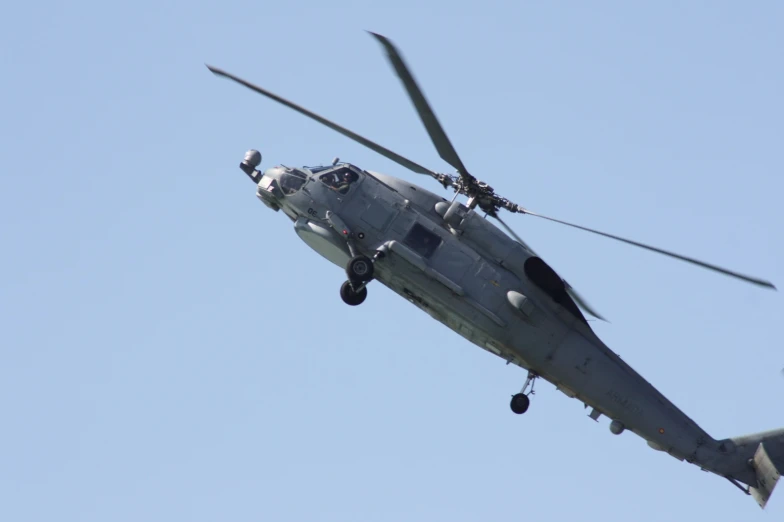 a large gray helicopter flying through a blue sky