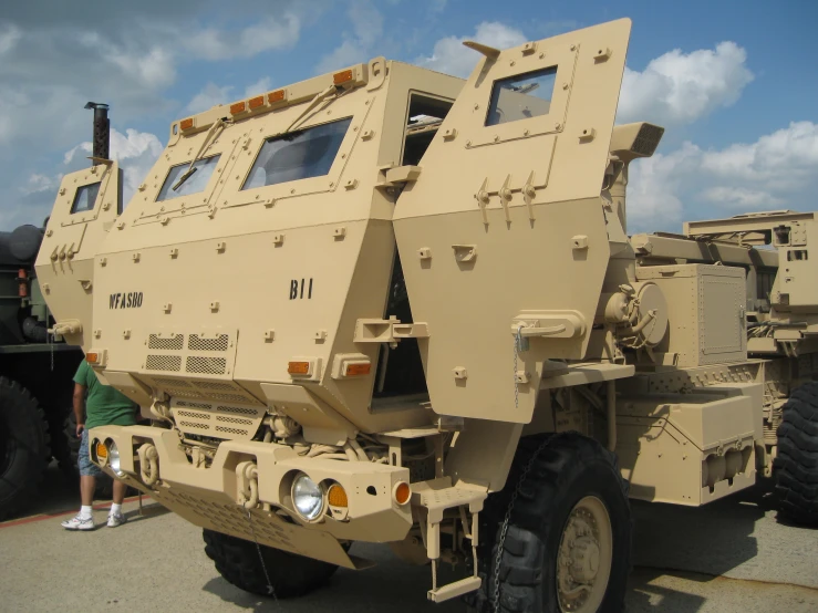 a beige truck with large tires and multiple lights