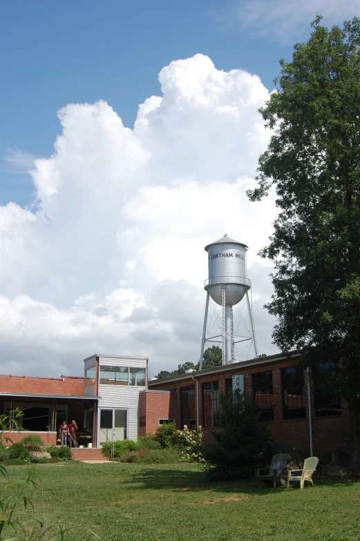 a large water tower sitting over an area with green grass