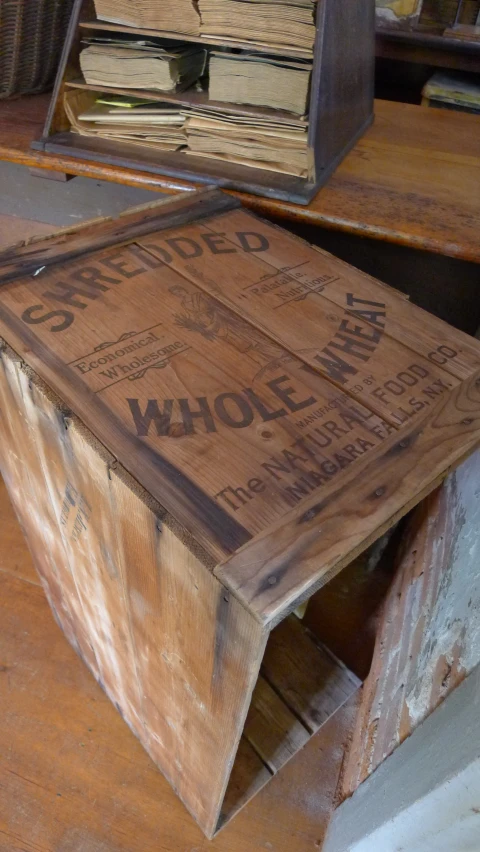 a wooden box on a table with two old magazines stacked in the background