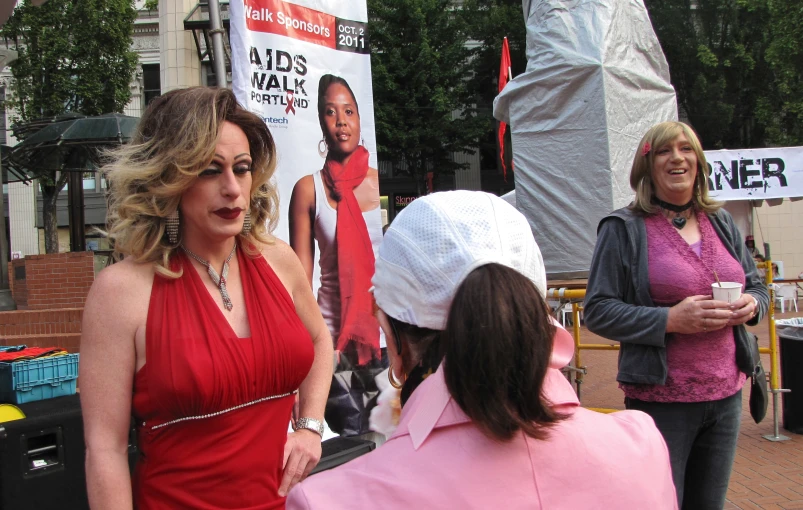 woman dressed in red with an afro talking to other women