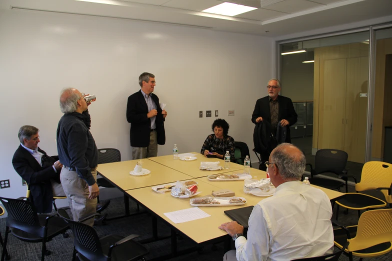 people gathered in an office meeting room for food