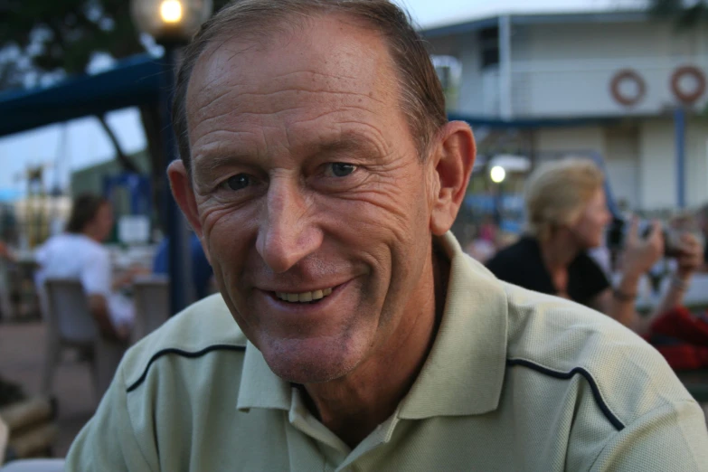 a close up of a man in a green shirt smiling