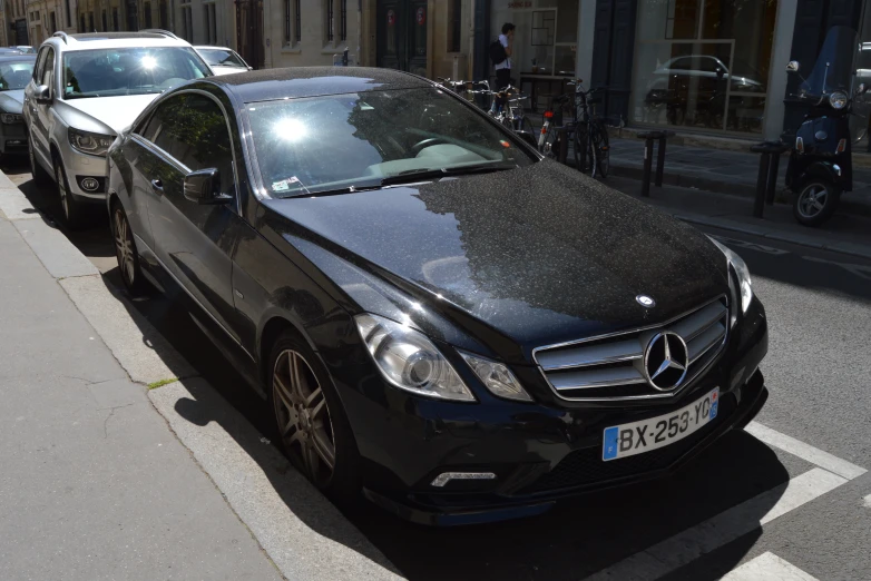 a mercedes is parked in a parking space near a street