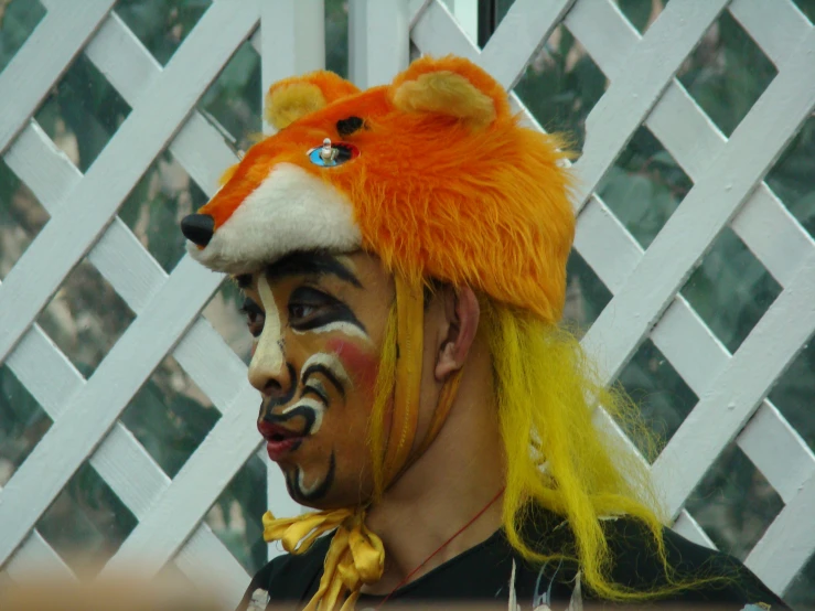 man in orange and black outfit with painted face