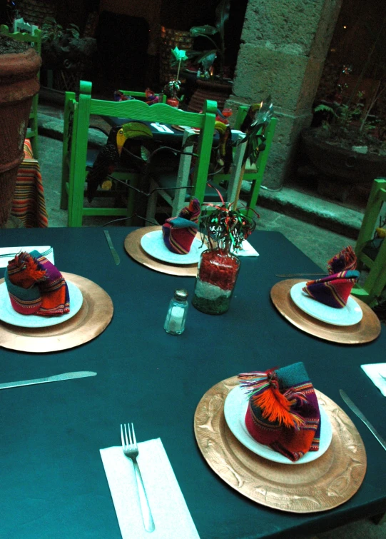 a blue table covered in place setting with a green table cloth